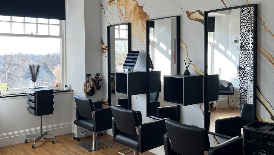 Modern salon interior at Hair by Keri Muir, Larbert, Scotland, GB with sleek black chairs and elegant decor.