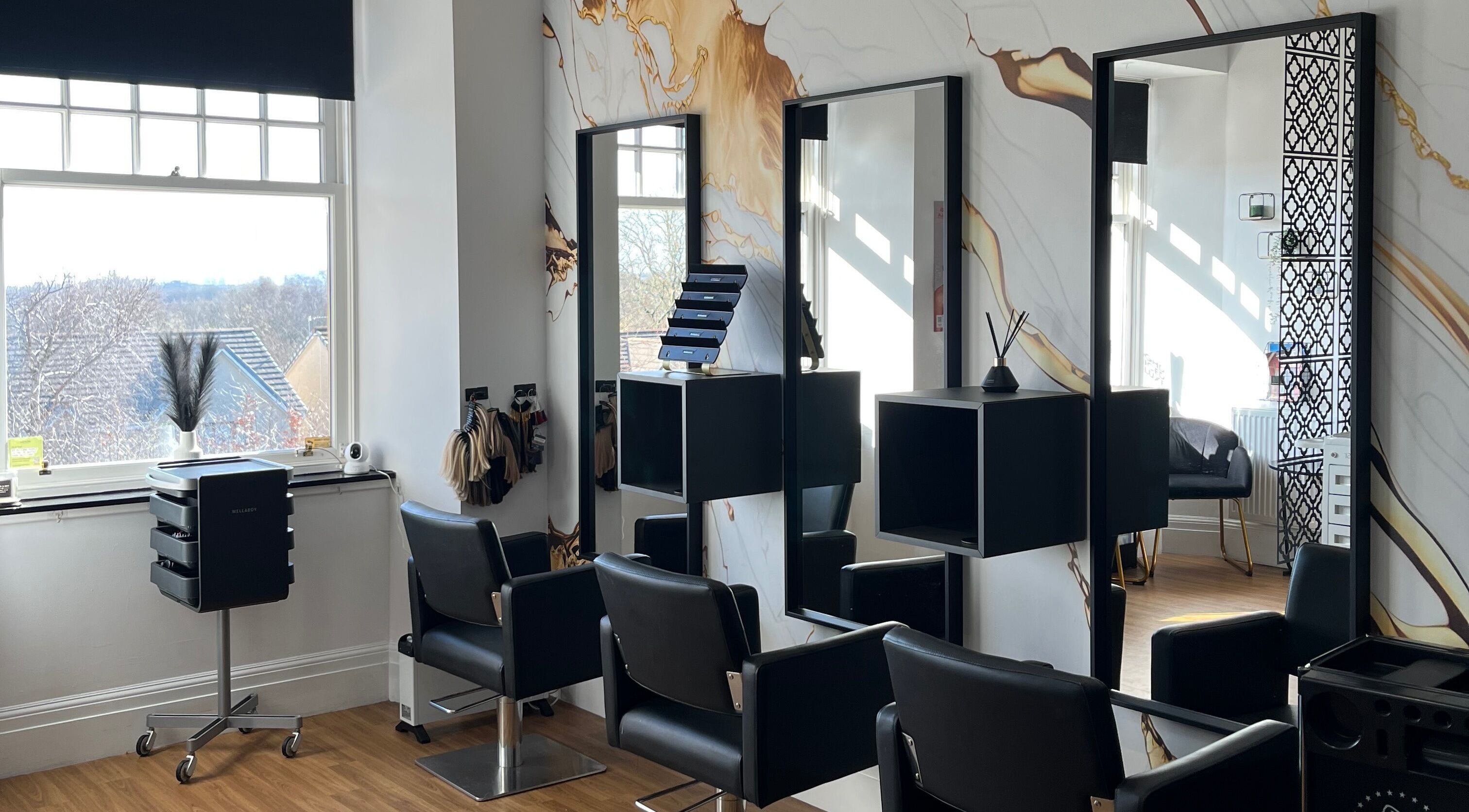 Modern salon interior at Hair by Keri Muir, Larbert, Scotland, GB with sleek black chairs and elegant mirrors.