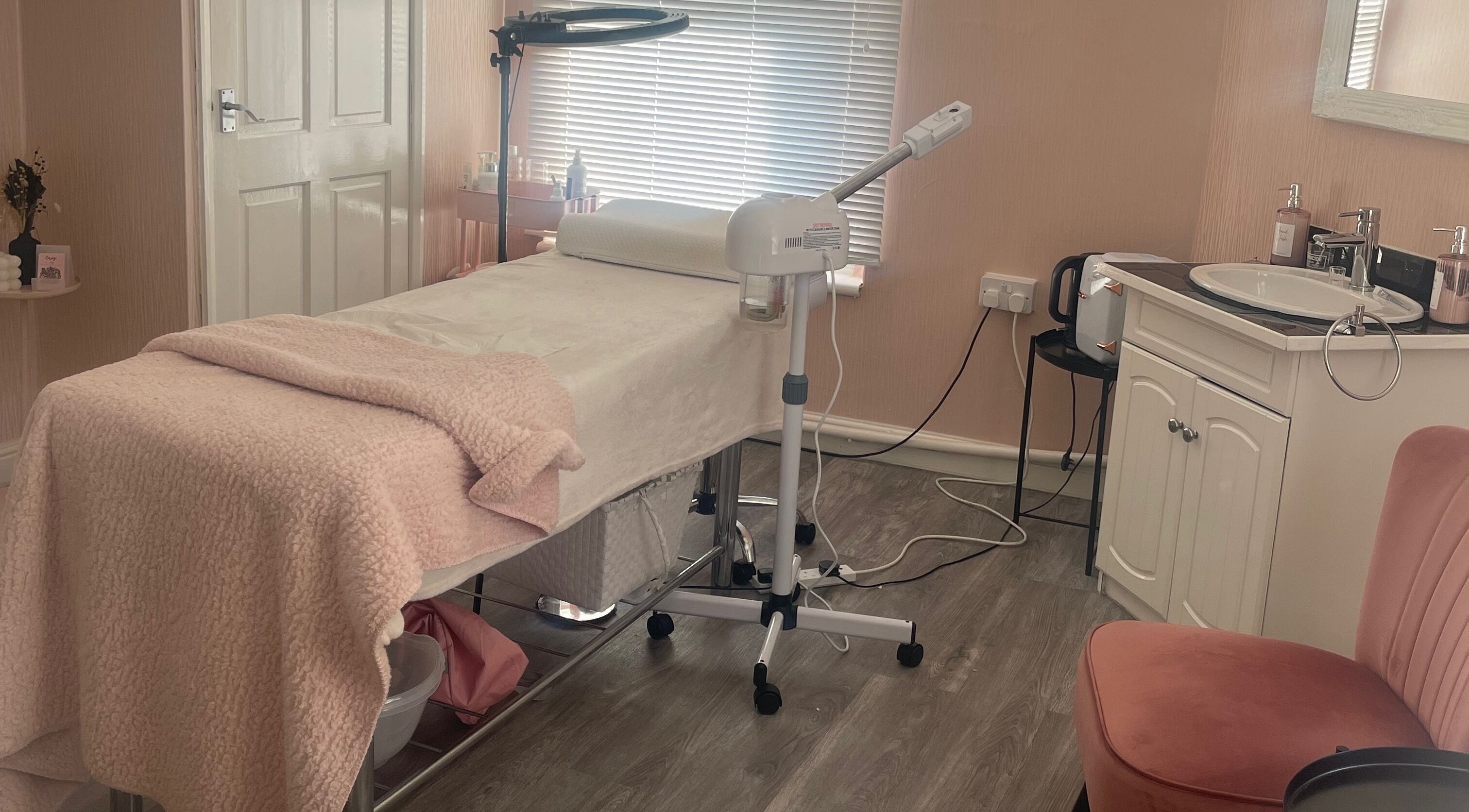 Cozy treatment room at Stephen Pyne Hair & Beauty, Walsall, England, GB with soft pink decor and modern equipment.