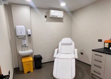 Treatment room at Natalie Mcintyre Aesthetics, Bishopbriggs, Scotland, GB featuring a white reclining chair.