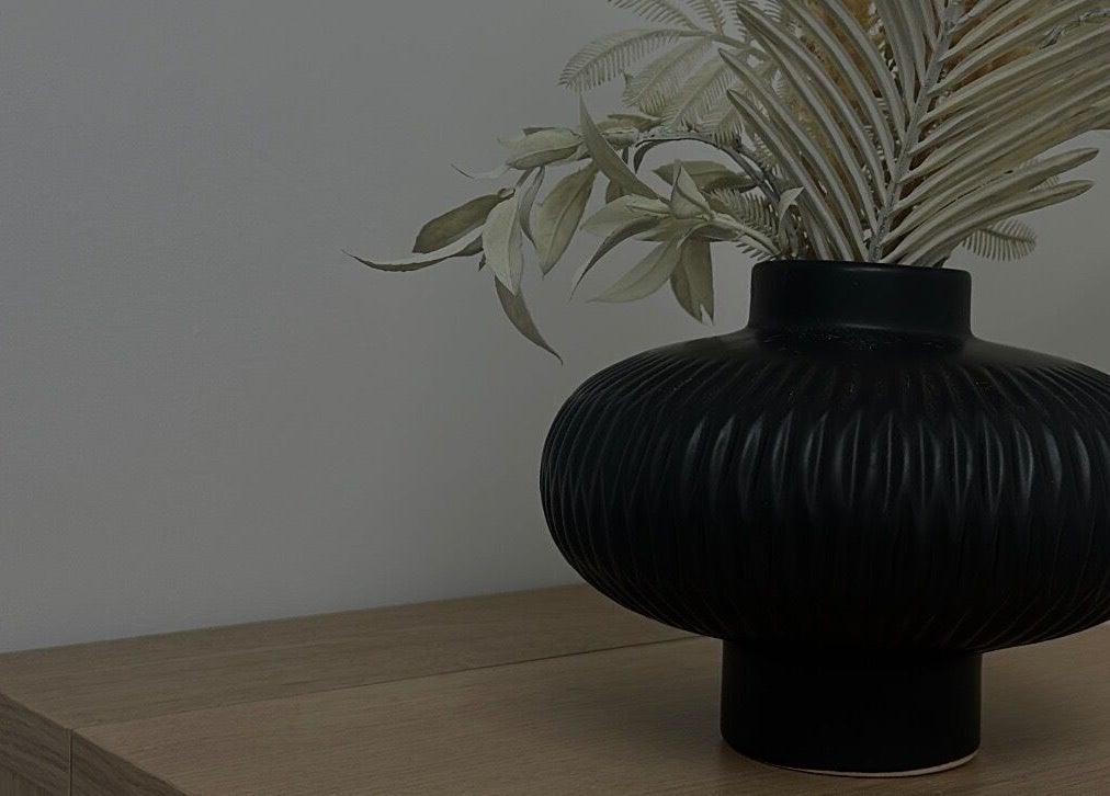Elegant black vase with foliage at Paint By Tate, Newport, Wales, GB.