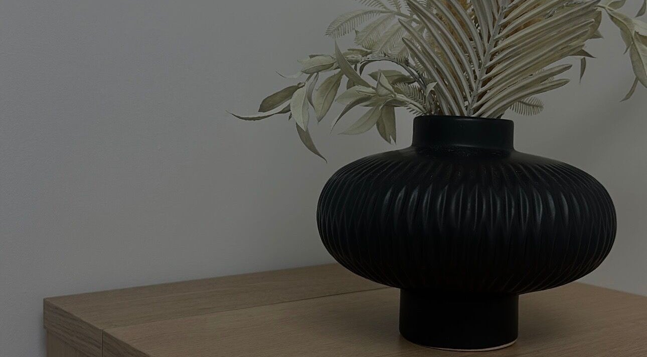 Elegant black vase with foliage at Paint By Tate, Newport, Wales, GB.
