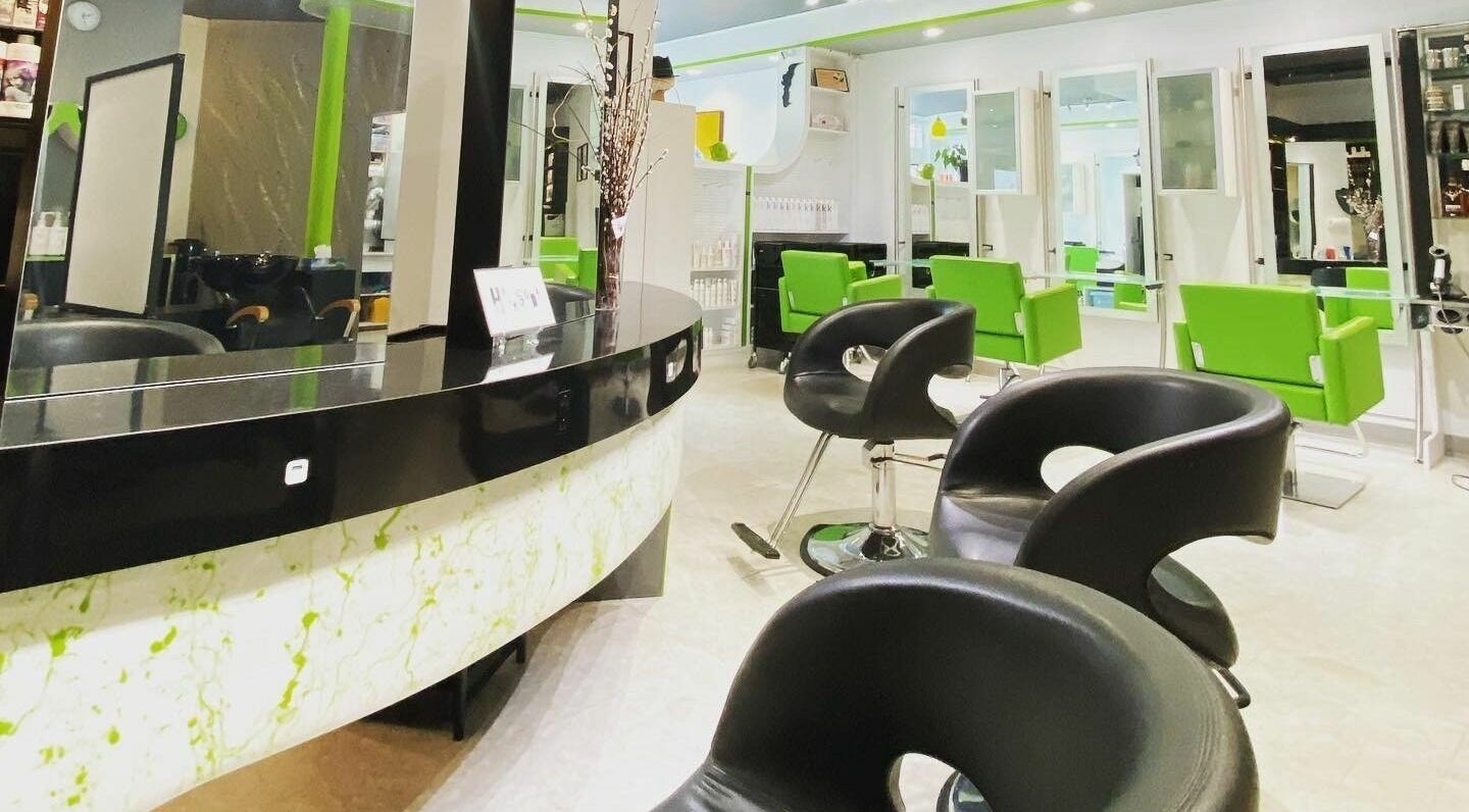 Sleek modern salon at Hairsoda, North Vancouver, British Columbia, CA with black chairs and vibrant green accents.