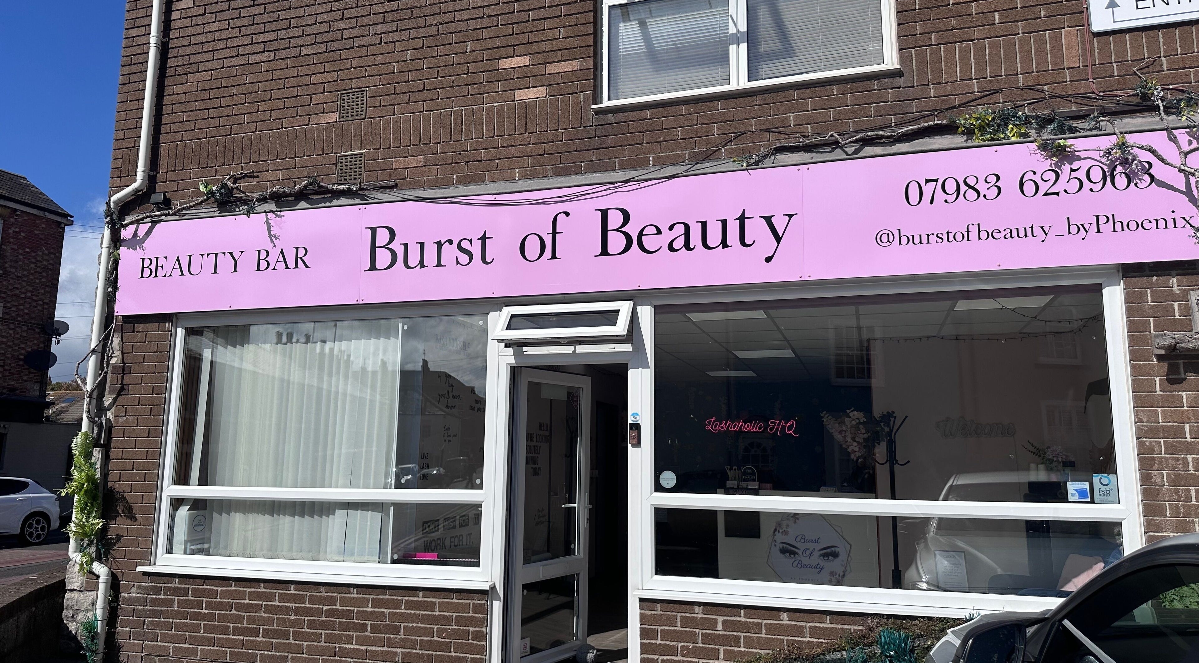 Entrance of Burst of Beauty, a beauty bar in Weymouth, England, GB with a pink sign and brick exterior.