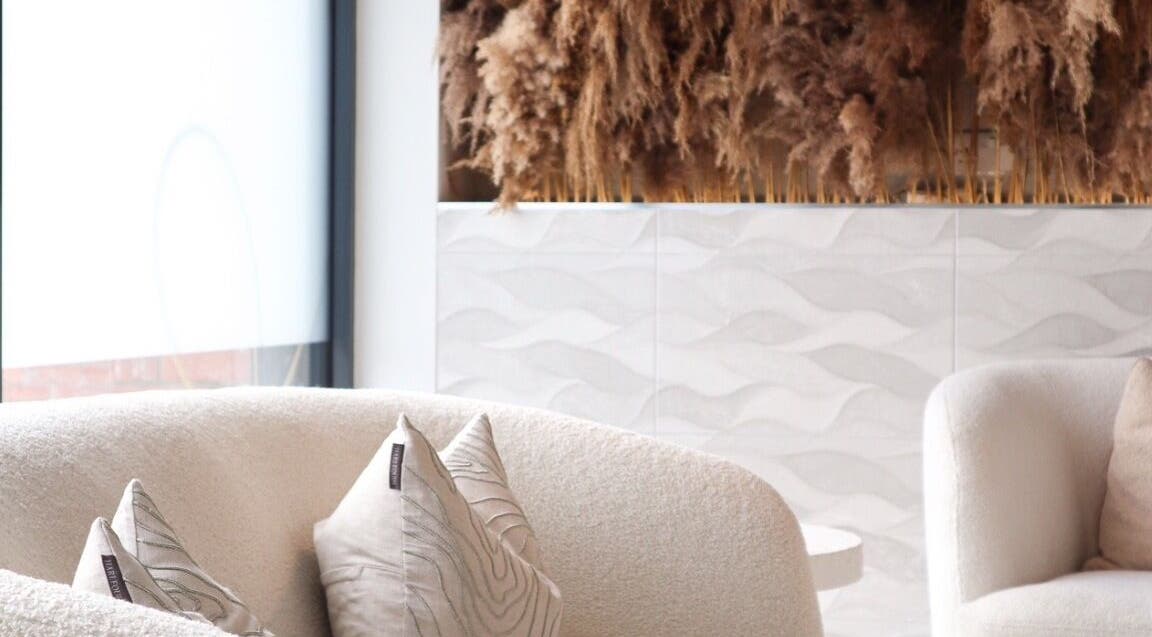 Elegant seating area at Enhance, Belfast, Northern Ireland, GB, featuring plush chairs and natural decor.