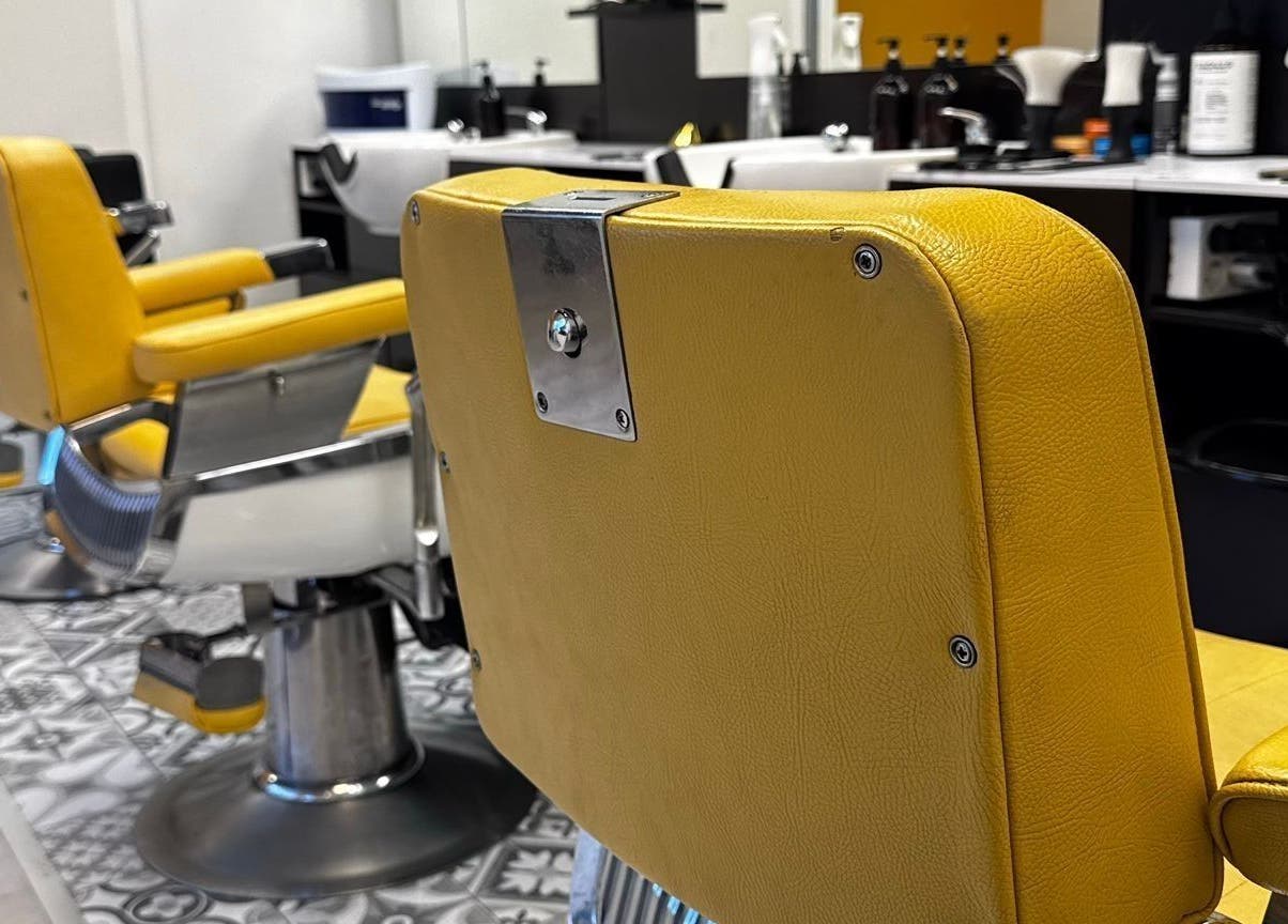 Sillas de barbero amarillas en Barberia Oro Negro (martinez garrido), Vigo, ES, reflejando estilo moderno.