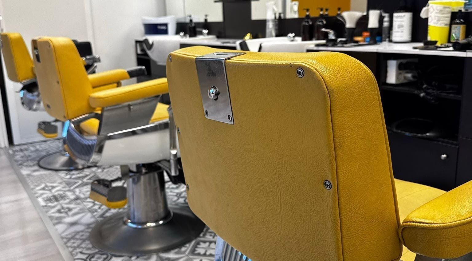 Sillas de barbero amarillas en Barberia Oro Negro (martinez garrido), Vigo, ES, reflejando estilo moderno.