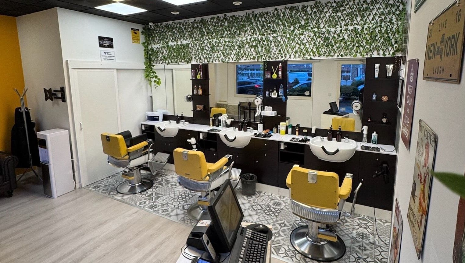 Interior moderno de Barberia Oro Negro (Martinez Garrido) en Vigo, ES, con sillas amarillas y decoración de plantas.
