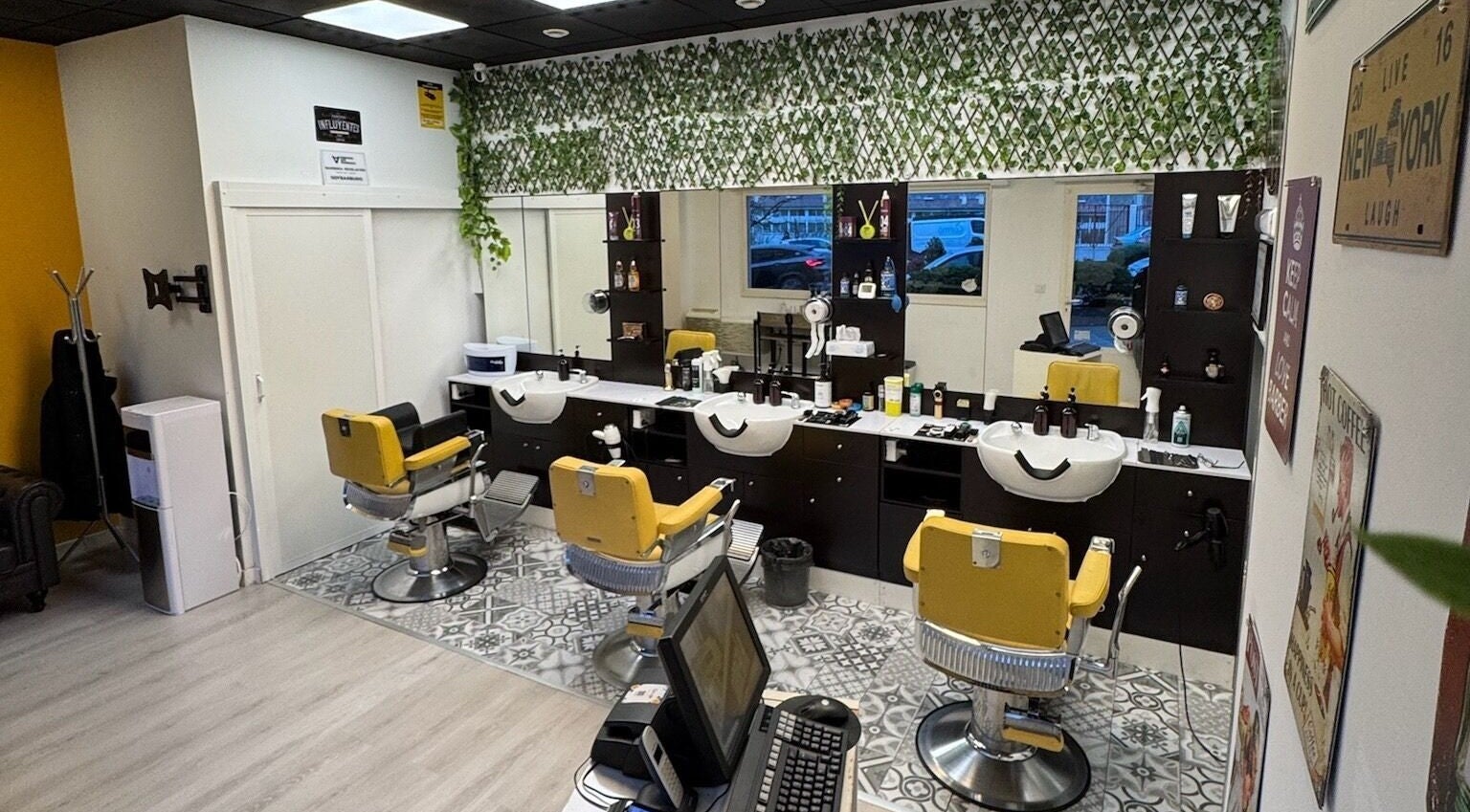 Interior moderno de Barberia Oro Negro (Martinez Garrido) en Vigo, ES, con sillas amarillas y decoración de plantas.