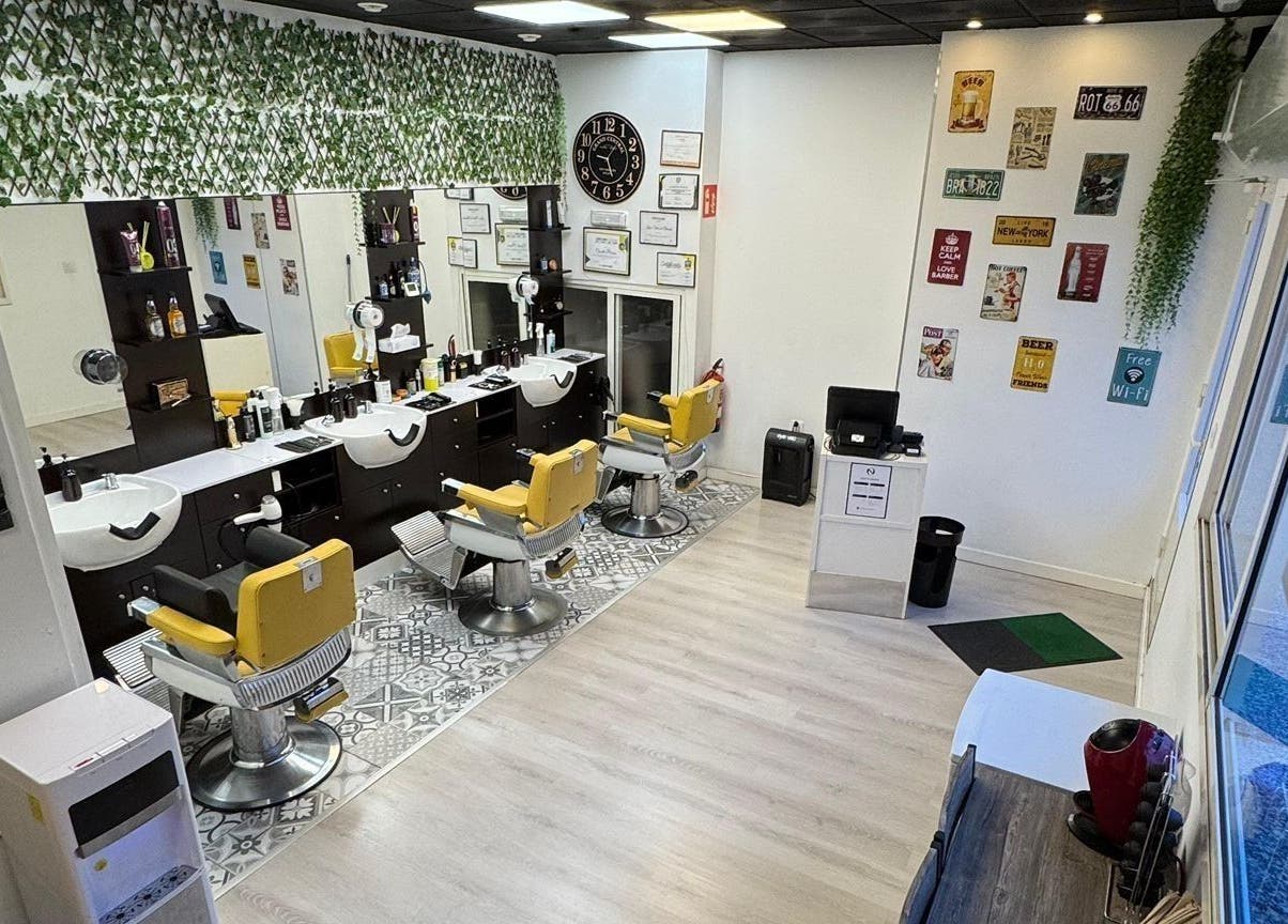 Interior moderno de Barberia Oro Negro, Vigo ES, con sillas amarillas y decoración vibrante.