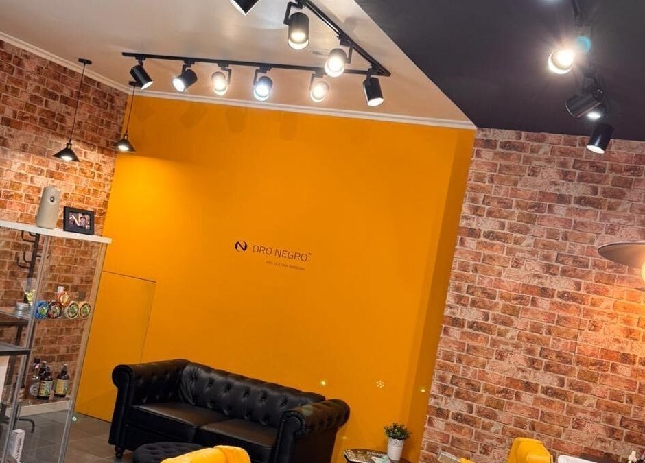 Interior de Barberia Oro Negro en Vigo, ES, con paredes de ladrillo y decoración moderna.