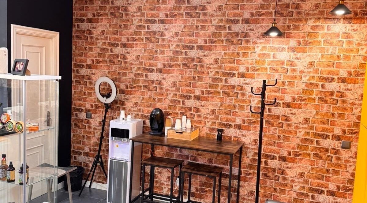 Interior acogedor en Barberia Oro Negro (salamanca), Vigo, ES, con pared de ladrillo y mesa de café.