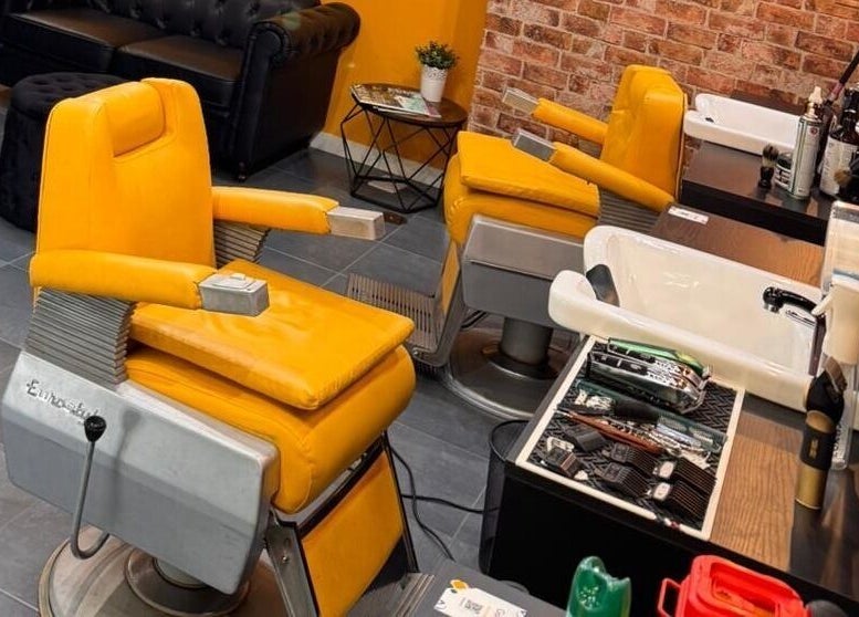 Interiores de Barberia Oro Negro con sillas de barbería amarillas en Vigo, ES.