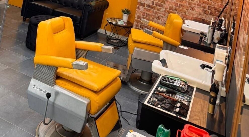 Interiores de Barberia Oro Negro con sillas de barbería amarillas en Vigo, ES.