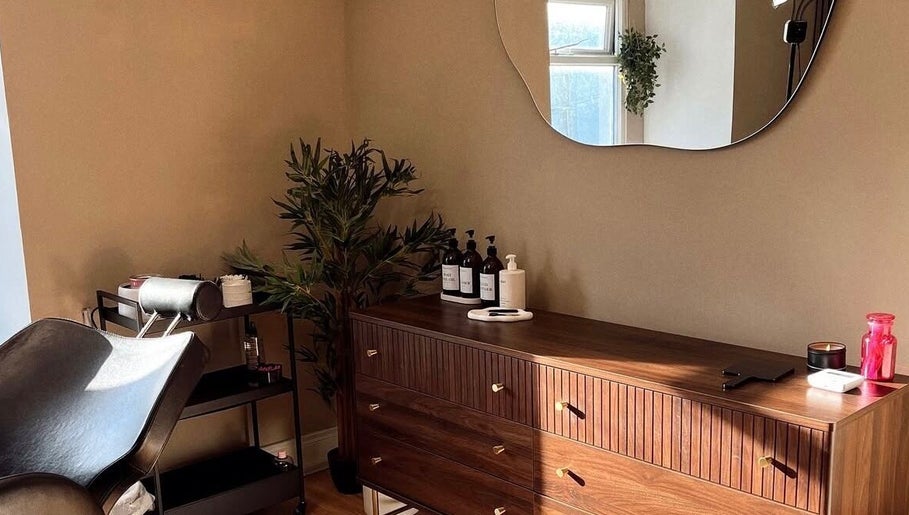 Elegant Caitlin Marie Makeup studio in Arklow, County Wicklow, IE with a stylish wooden dresser and mirror.