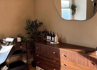 Elegant Caitlin Marie Makeup studio in Arklow, County Wicklow, IE with a stylish wooden dresser and mirror.