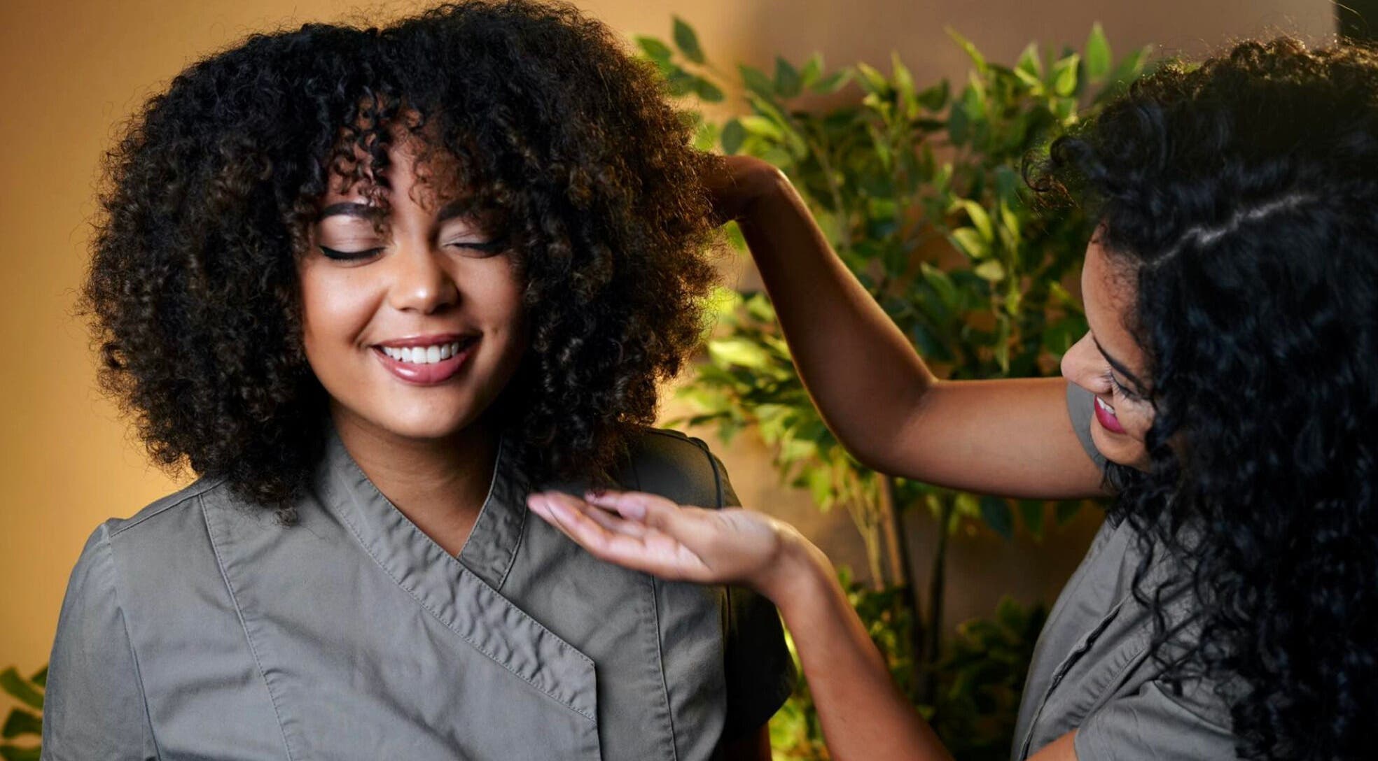 Stylists at Doctor Curlz perfecting curls in Paradijswijk, AW, with lush greenery around.