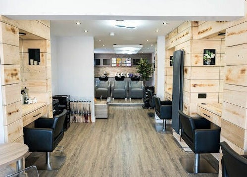 Chic salon interior at Marcia & Co, Freckleton, England, GB, featuring modern black chairs and wooden accents.