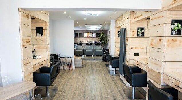 Chic salon interior at Marcia & Co, Freckleton, England, GB, featuring modern black chairs and wooden accents.