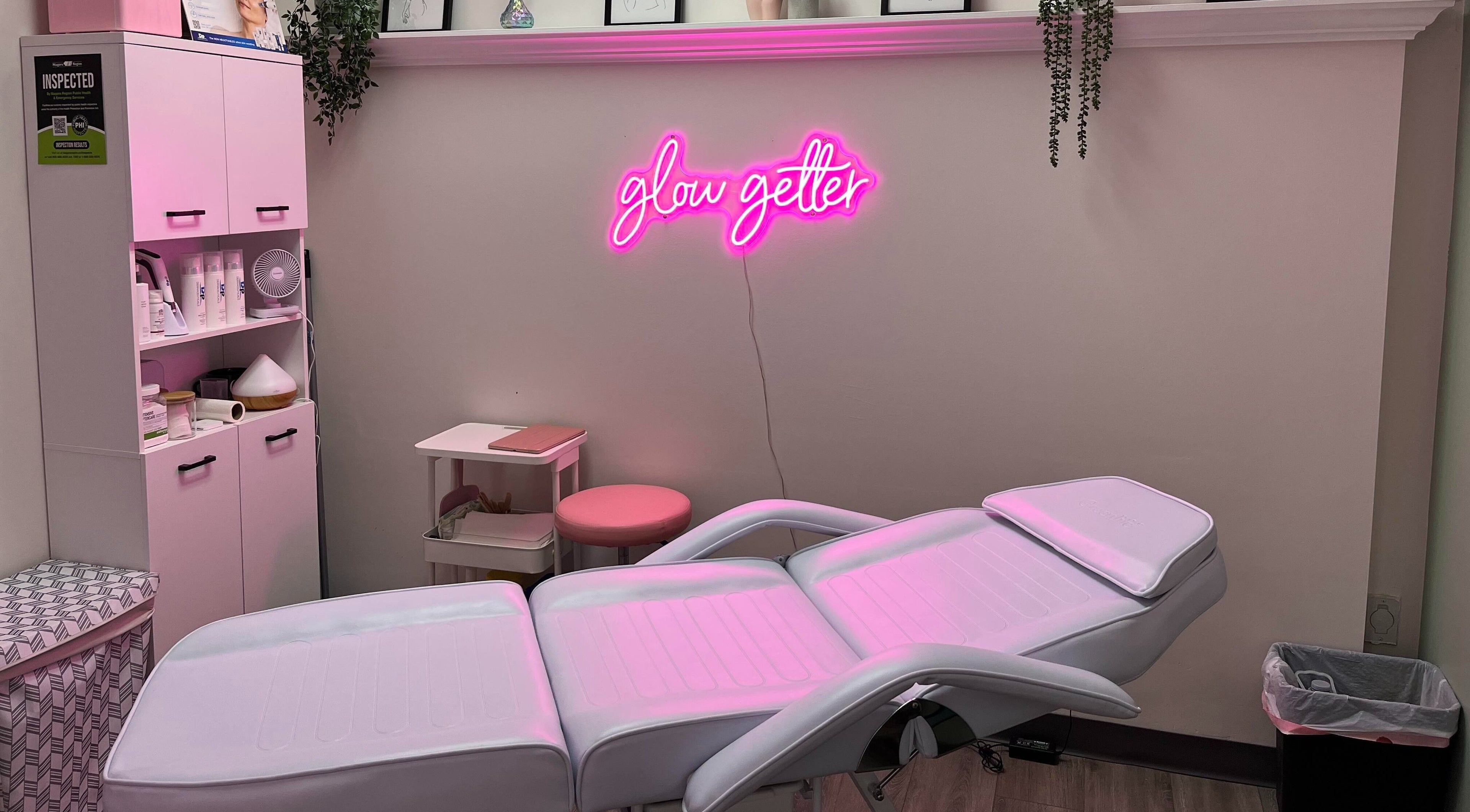 Modern treatment room with pink neon sign at 707 Laser & Esthetics, St. Catharines, Ontario, CA.