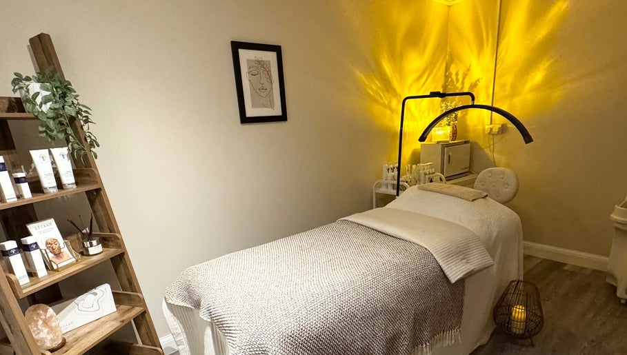 Cozy treatment room at Radiant Skin Clinic, Peterborough, England, GB with warm lighting and skincare products.