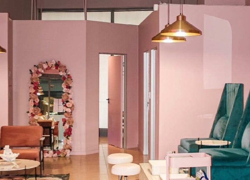 Ellainc Beauty Nail Bar's chic interior in Cape Town, Western Cape, ZA with plush teal seating and floral decor.