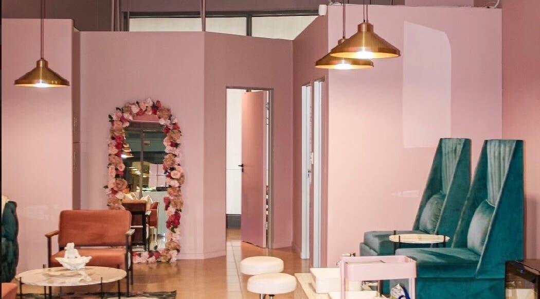 Ellainc Beauty Nail Bar's chic interior in Cape Town, Western Cape, ZA with plush teal seating and floral decor.