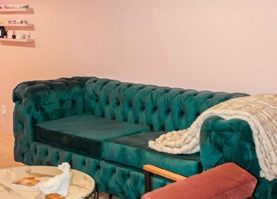 Chic green sofa with cozy blanket in Ellainc Beauty Nail Bar, Cape Town, Western Cape, ZA.
