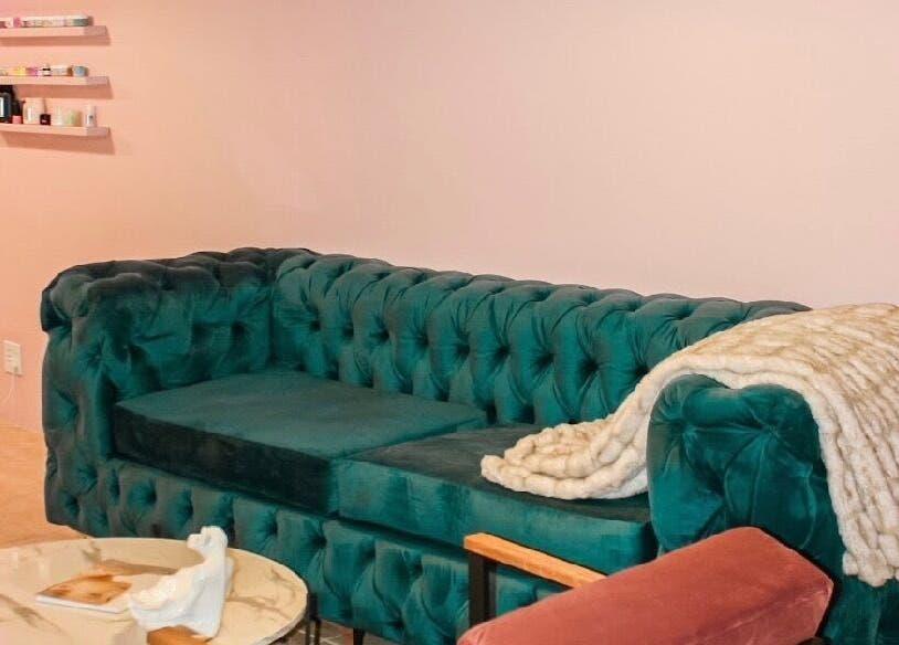 Chic green sofa with cozy blanket in Ellainc Beauty Nail Bar, Cape Town, Western Cape, ZA.