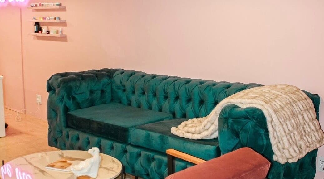 Chic green sofa with cozy blanket in Ellainc Beauty Nail Bar, Cape Town, Western Cape, ZA.