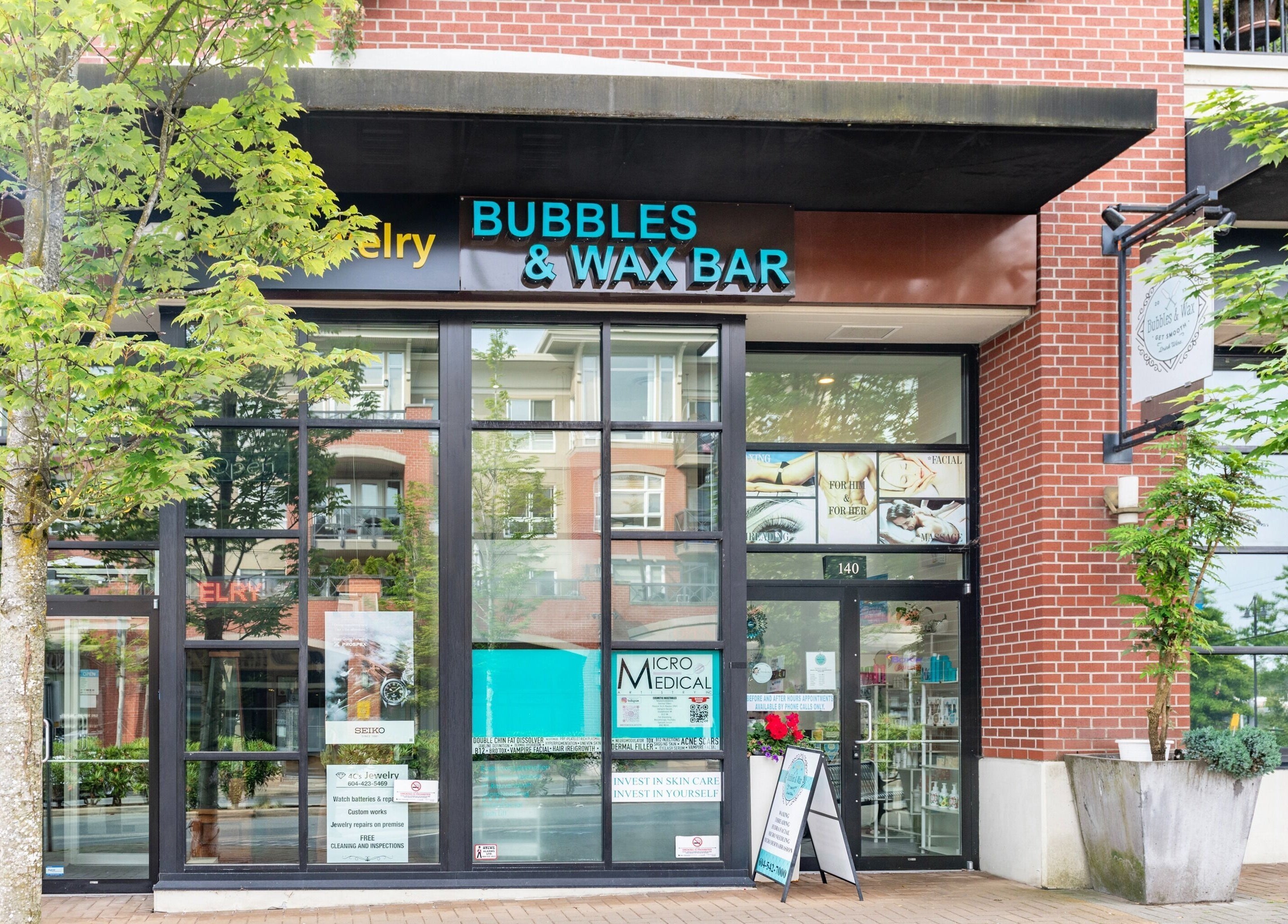 Front entrance of Bubbles and Wax Bar in Surrey, British Columbia, CA with glass windows and signage.