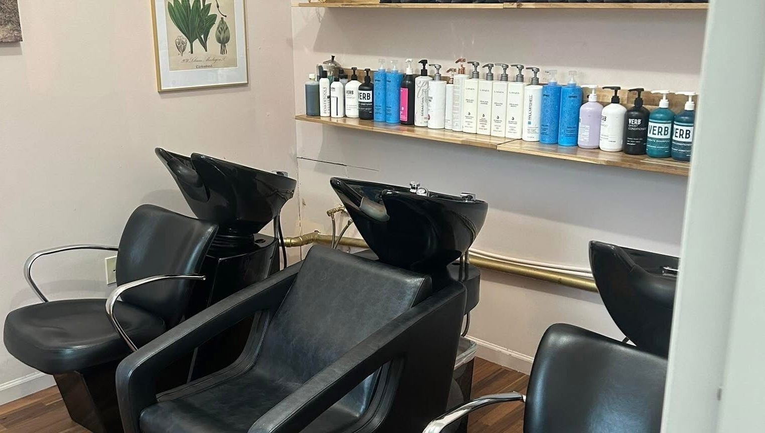 Elegant hair wash area at Haley Stapleton, Matthews, North Carolina, US, with modern black chairs and products.