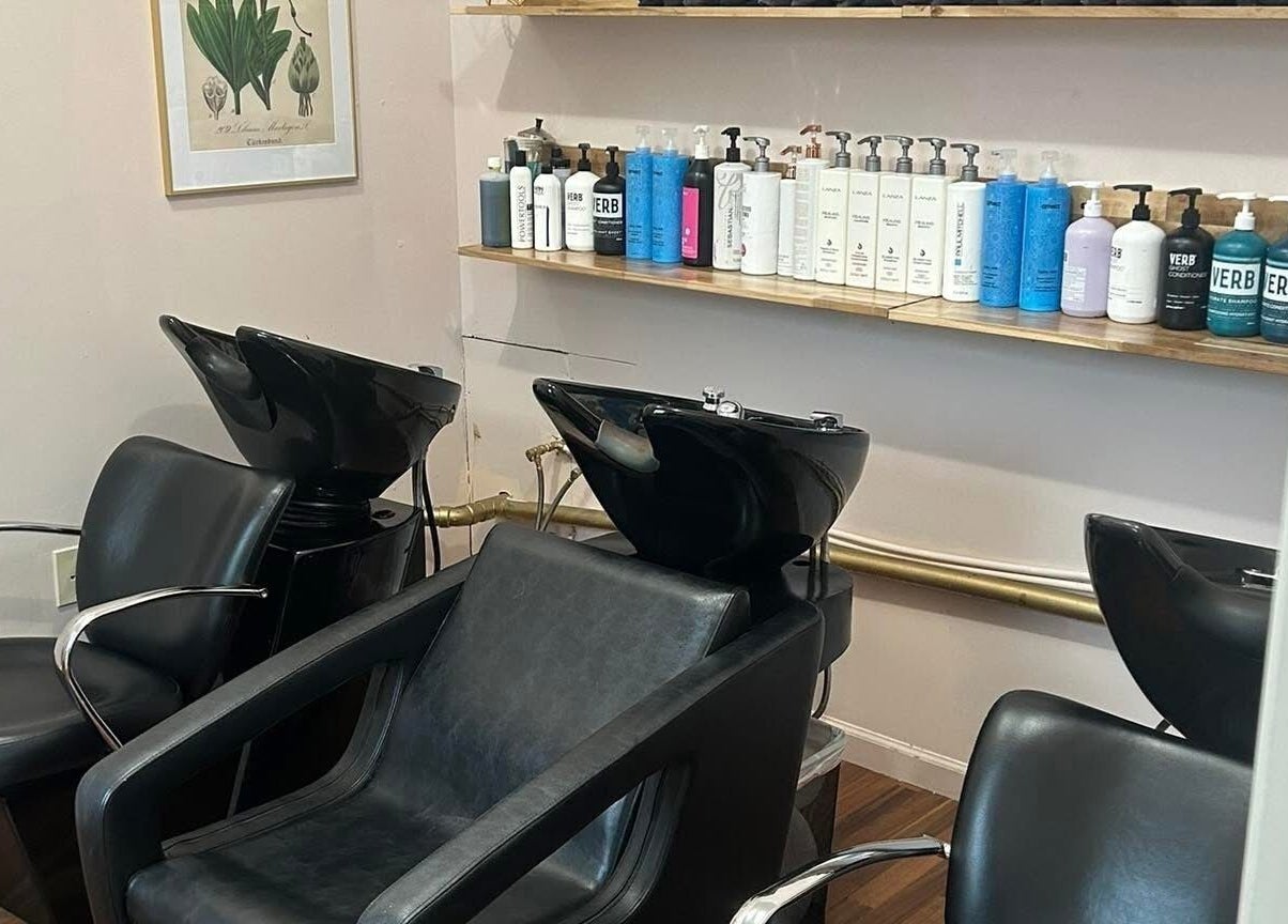 Elegant hair wash area at Haley Stapleton, Matthews, North Carolina, US, with modern black chairs and products.