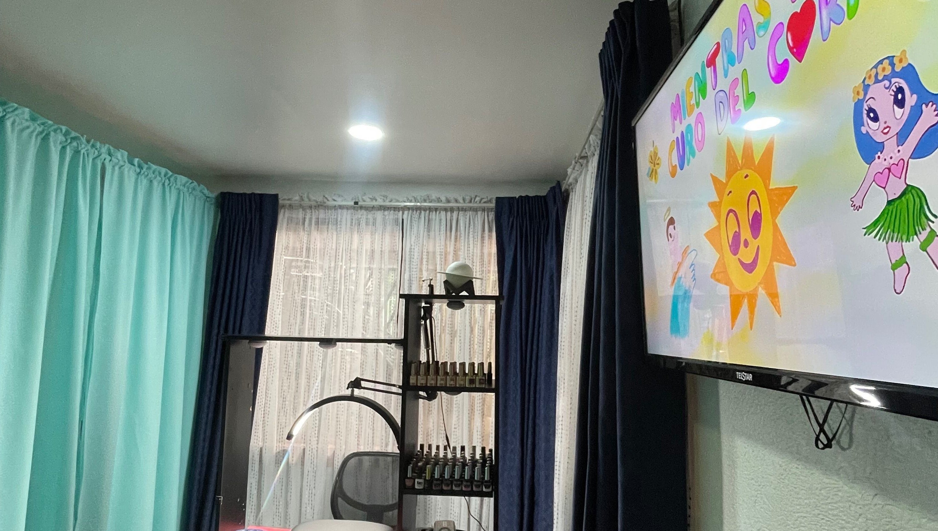 Interior de Saturno Nails en Concepción, Provincia De Cartago, CR con cortinas coloridas y pantalla ilustrativa.