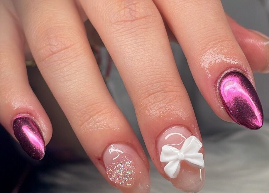 Manicura llamativa en Saturno Nails Concepción, Provincia De Cartago, CR, con diseño metálico y lazo blanco.