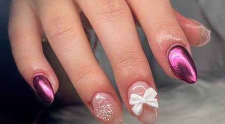 Manicura llamativa en Saturno Nails Concepción, Provincia De Cartago, CR, con diseño metálico y lazo blanco.