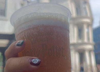 Mano con uñas de Saturno Nails sosteniendo vaso en Concepción, Provincia De Cartago, CR.