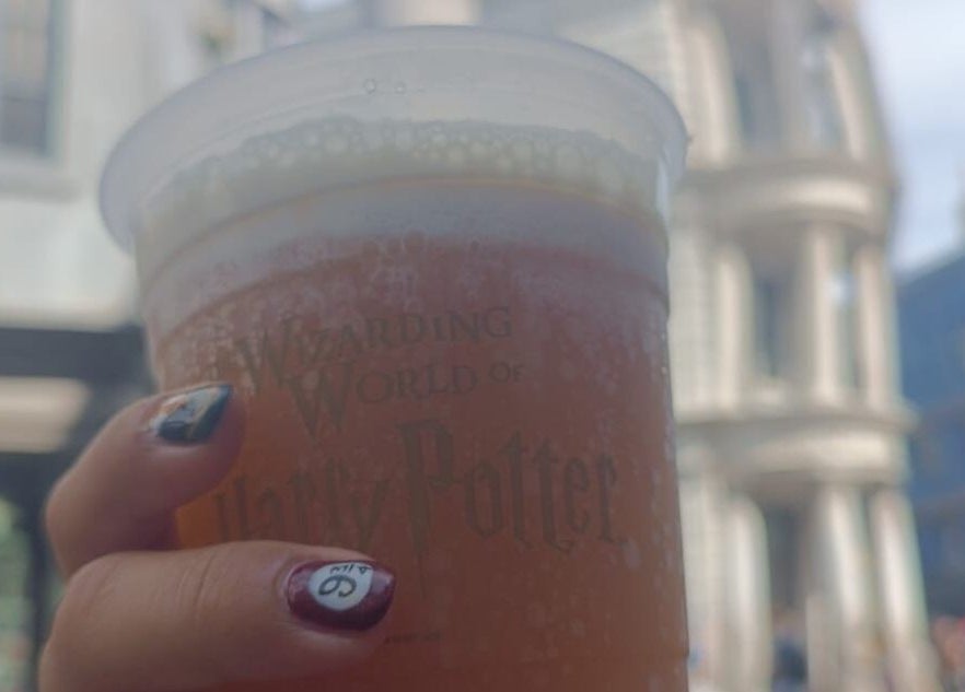 Mano con uñas de Saturno Nails sosteniendo vaso en Concepción, Provincia De Cartago, CR.