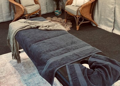 Cozy massage room at Synergy Fitness and Wellbeing, Melbourne, Victoria, AU featuring a comfy table and chairs.