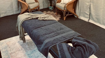 Cozy massage room at Synergy Fitness and Wellbeing, Melbourne, Victoria, AU featuring a comfy table and chairs.