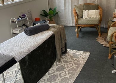 Cozy massage room at Synergy Fitness and Wellbeing, Melbourne, Victoria, AU with wooden chairs and soft lighting.