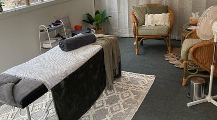 Relaxing therapy room at Synergy Fitness and Wellbeing, Melbourne, Victoria, AU with massage table and seating area.