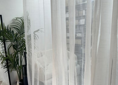 Elegant interior with white curtains and lush plants at PRF London | JazLooks, Wembley, England, GB.