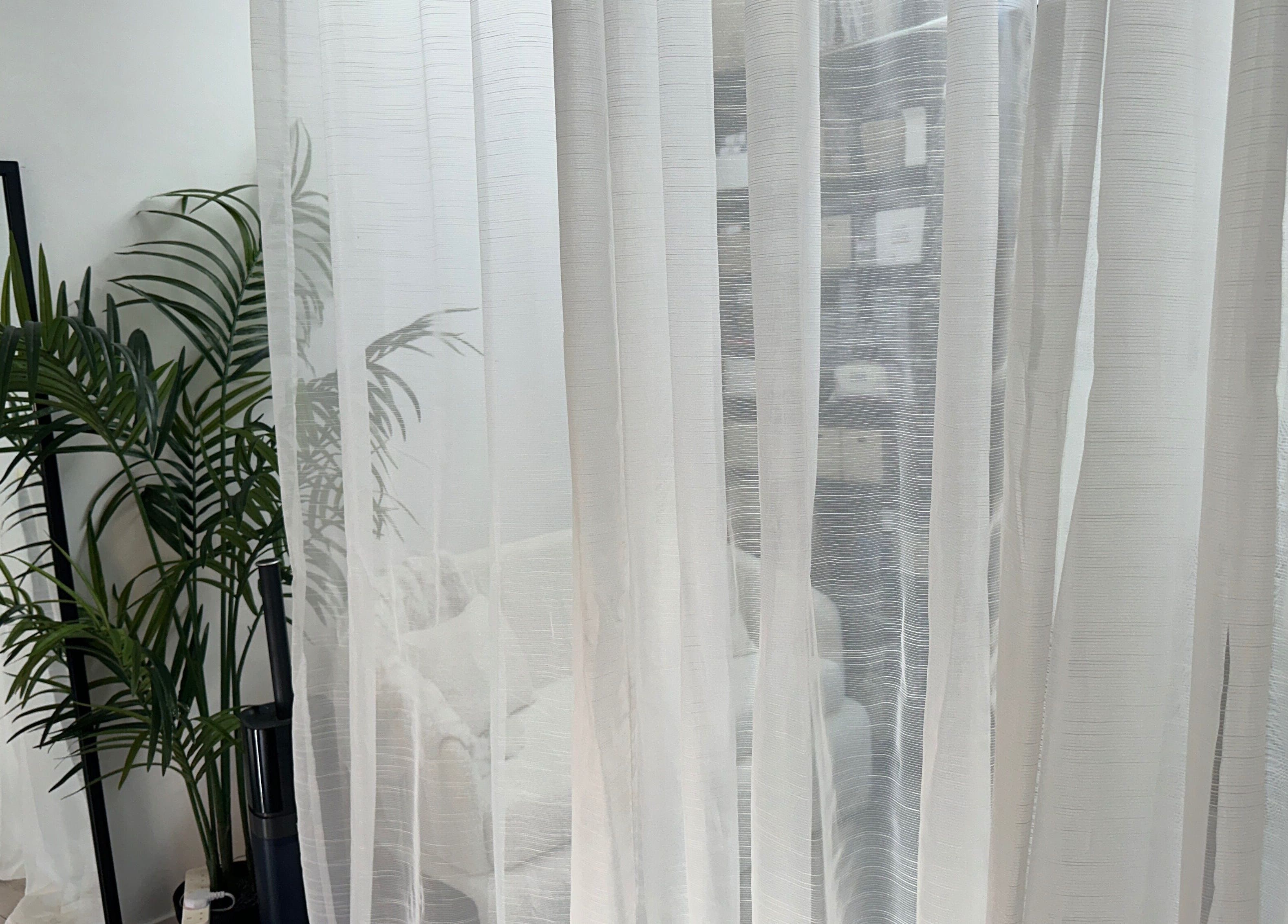 Elegant interior with white curtains and lush plants at PRF London | JazLooks, Wembley, England, GB.