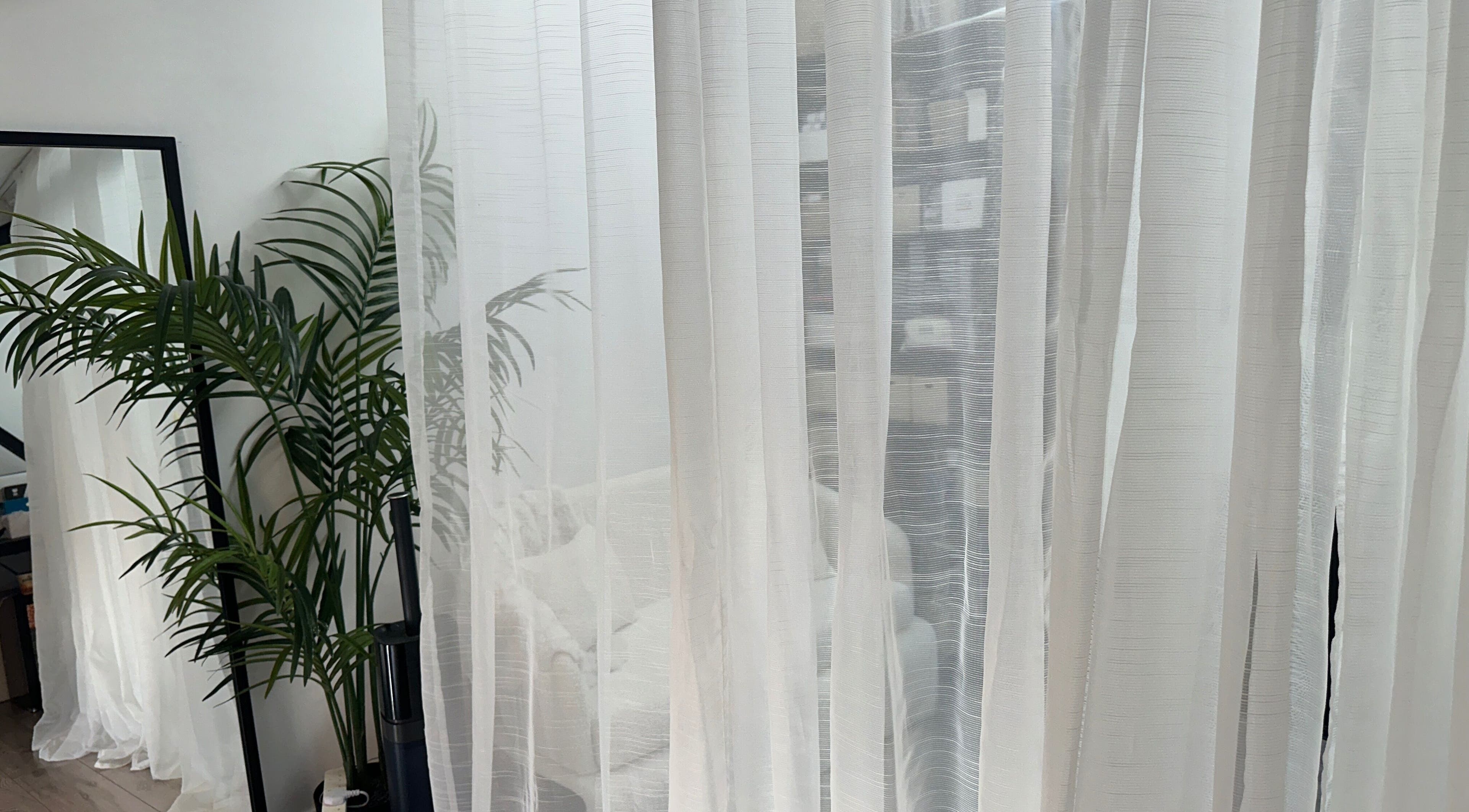 Elegant interior with white curtains and lush plants at PRF London | JazLooks, Wembley, England, GB.