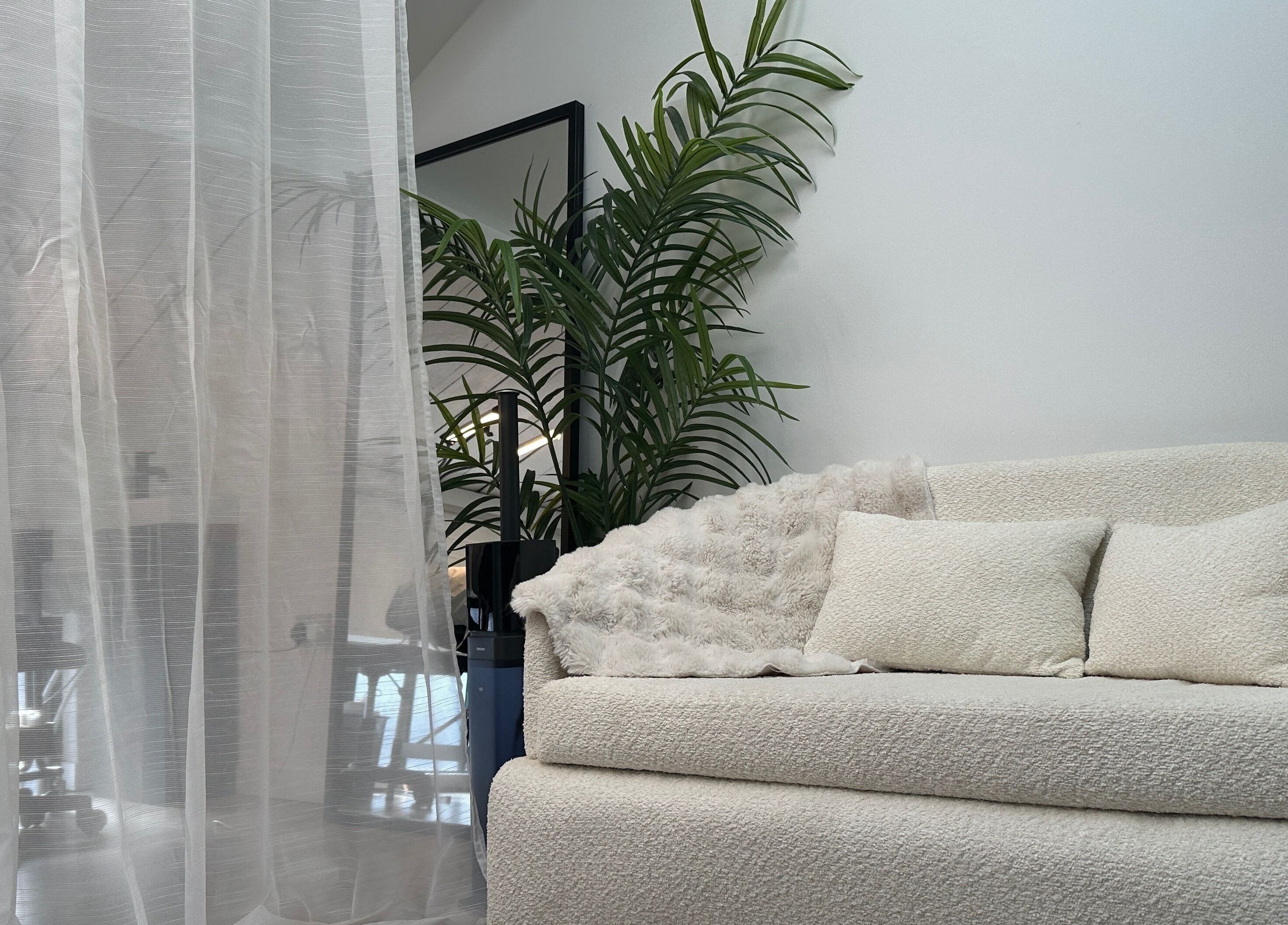 Elegant lounge area at PRF London | JazLooks in Wembley, England, GB with plush sofa and greenery.