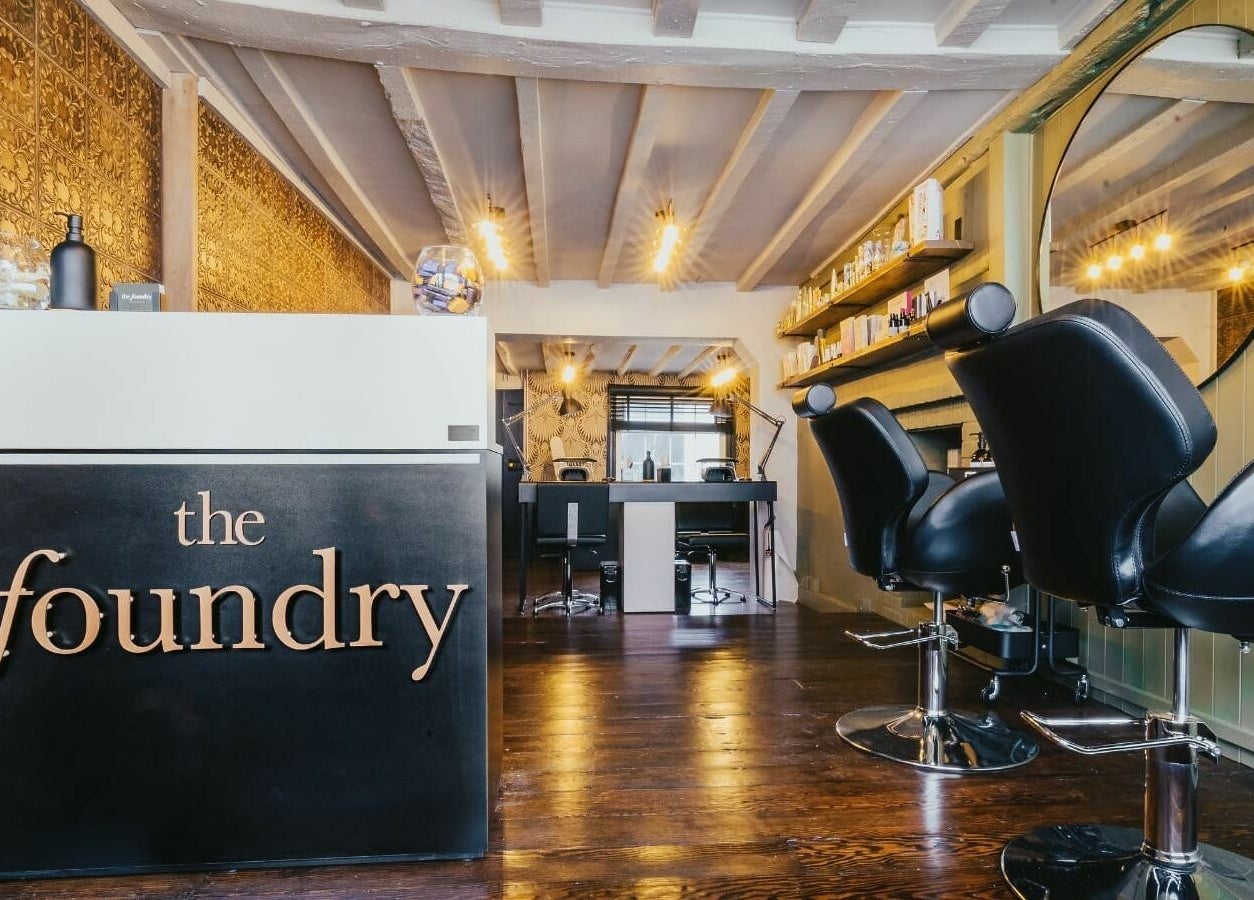 Stylish interior of The Foundry salon in Cranbrook, England featuring modern chairs and decor.