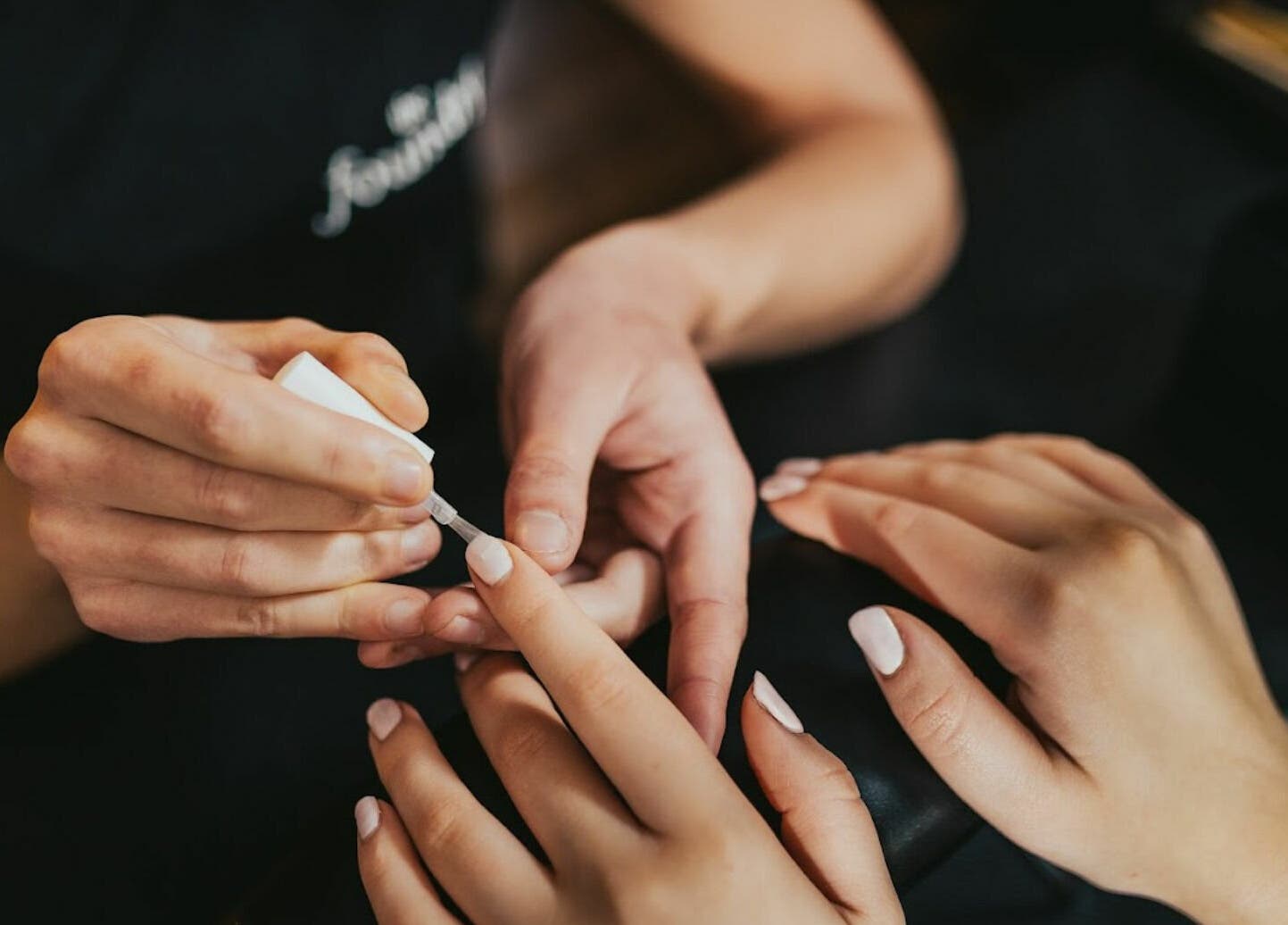 Nail artist applying polish at The Foundry, Cranbrook, England, GB for a perfect manicure.