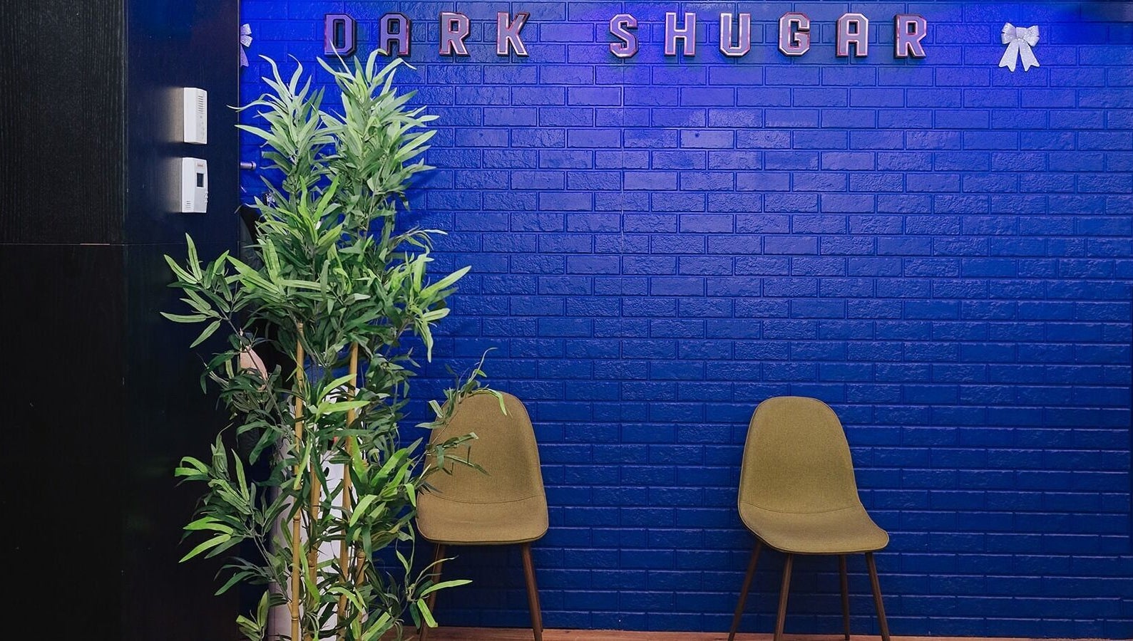 Relaxing lounge area at Dark Shugar Hair & Beauty Studios, St Vital in Winnipeg, Manitoba, CA with blue walls.