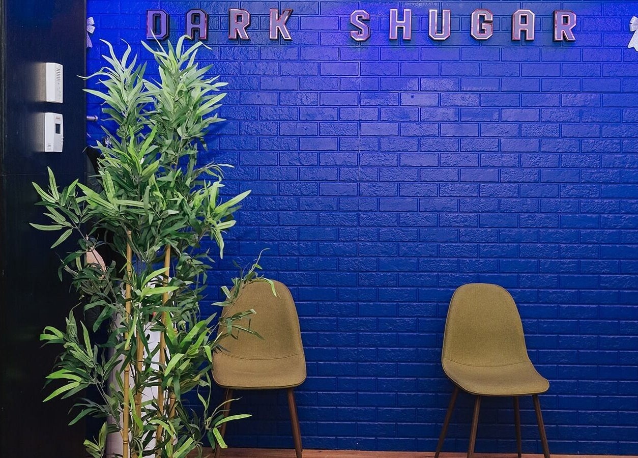Relaxing lounge area at Dark Shugar Hair & Beauty Studios, St Vital in Winnipeg, Manitoba, CA with blue walls.